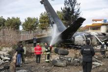Des pompiers et des forces de sécurité interviennent sur le lieu du crash d'un avion militaire iranien près de Téhéran, le 14 janvier 2019