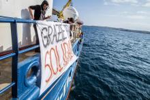 Des militants d'aide aux migrants à bord du "Sea Watch 3", qui a jeté l'ancre près de Syracuse (est de la Sicile), déploient une banderole en italien "Merci pour la solidarité", le 26 janvier 2019.