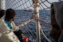 Des migrants à bord du Sea Watch 3 observent un bateau des garde-côtes italiens
