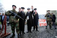 Des "anti-Brexit" vêtus comme des soldats et douaniers britanniques devant une banderole concrétisant la frontière physique entre l'Irlande du nord et l'Irlande à Newry, le 26 janvier 2019