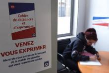 Une femme inscrit ses doléances sur le "cahier de doléances et d'espérances" mis à disposition dans huit mairies de quartier à Bordeaux, le 18 janvier 2019