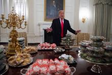 Le président américain Donald Trump devant la nourriture qu'il a achetée à l'occasion de la réception à la Maison Blanche d'une équipe de football américain, le 14 janvier 2019