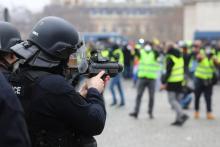 Un policier vise des manifstants avec un LBD, place de l'Etoile à Paris le 12 janvier 2019