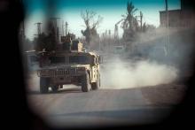 Un véhicule américain pris en photo depuis une voiture dans le village de Baghouz, dans l'est de la Syrie, d'où les Forces démocratiques syriennes (FDS) ont chassé la plupart des jihadistes du groupe 