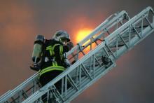 Des pompiers sur une grande échelle interviennent sur un incendie à Lens