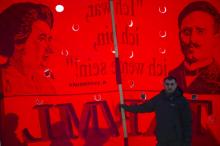 Un homme devant une banderole représentant Rosa Luxemburg et Karl Liebknecht, le 15 janvier 2012 à Berlin
