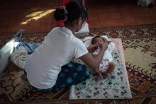 Une jeune mère non mariée prise en charge par l'ONG Myint Mo Myittar prépare son bébé avant de le confier à un orphelinat pour adoption, le 19 octobre 2018 à Thanlyin, en Birmanie