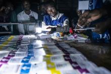 Des agents de la Commission électorale nationale indépendante (Céni) comptent les bulletins de vote de la présidentielle en République démocratique du Congo, lors d'une coupure d'électricité à Lubumba