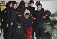 L'Indonésienne Siti Aisyah (c) et la Vietnamienne Doan Thi Huong (c, en haut), meurtrières présumées de Kim Jong Nam, escortées par la police malaisienne à la sortie du tribunal de Shah Alam, le 14 dé