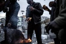 Des migrants se réchauffent autour d'un brasero, le 10 janvier 2019 à Saint-Denis, près de Paris