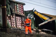 Un employé des chemins de fer passe devant les wagons endommagés d'un train de marchandises sur le pont du Grand Belt au Danemark après un accident meurtrier, le 2 janvir 2019