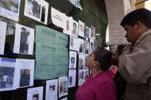 Des habitants consultent le mur affichant les identités des personnes portées disparues après l'explosion d'un oléoduc, le 20 janvier 2019 à Tlahuelilpan (Mexique)
