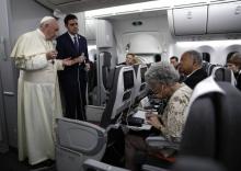 Le pape François avec son porte-parole Alessandro Gisotti (d) répond aux journalistes dans son avion le ramenant des JMJ au Panama, le 27 janvier 2019