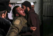 Un Palestinien tente de calmer un proche de Mohammed al-Nabahine, un militant du mouvement islamiste palestinien Hamas, tué par un tir de char israélien le 22 janvier 2019 dans la bande de Gaza