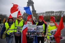 Des femmes "gilets jaunes", montrant des photos de manifestants blessés par les forces de l'ordre, manifestent à Paris le 20 janvier 2019