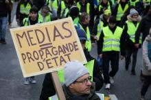 Un "gilet jaune" tient une pancarte "Médias = propagande d'Etat", le 12 janvier 2019 à Paris
