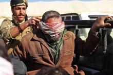 Un membre présumé du groupe jihadiste Etat islamique est assis à l'arrière d'un pick-up, les yeux bandés, pour être examiné par les Forces démocratiques syriennes, le 30 janvier 2019