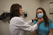 Un médecin ausculte une patiente atteinte de la grippe.
