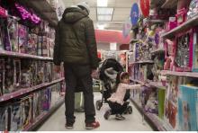 Une fillette et son père dans un magasin de jouets.