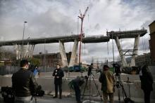 Les médias observent l'amorce de la descente d'un tronçon du pont Morandi dans le cadre de son démantèlement, à Gênes (Italie) le 9 février 2019