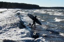 La surfeur Daniil Novozhilov, 30 ans, entre dans les eaux glacées du golfe de Finlande près du village de Lipovo près de Saint-Petersbourg le 17 février 2019