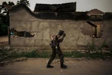 Un membre des forces armées congolaises passe devant un immeuble incendié à Yumbi dans l'ouest de la RDCongo, le 1er février 2019