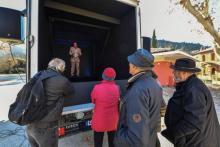 Des gens écoutent le discours de l'hologramme d'um membre de La France insoumise dans un des "holovans" du parti, le 6 février à Sospel (Alpes-maritimes), en vue des élections européennes de mai