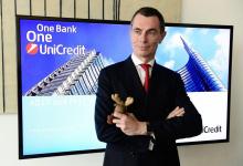 Le patron de la banque italienne UniCredit, le français Jean-Pierre Mustier, pose avec sa mascotte lors d'une conférence de presse, le 8 février 2018 à Milan