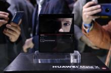Des visiteurs prennent des photos du Mate X, le smartphone pliable dévoilé par Huawei à la veille de l'ouverture du Mobile Wolrd Congress à Barcelone, le 24 février 2019