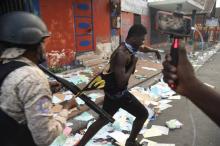 Des policiers haïtiens tentent d'arrêter un homme suspecté de pillage dans une rue de Port-au-Prince le 12 février 2019