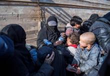 Une Française en niqab noir entouré de ses enfants s'exprimant après avoir fui le dernier réduit du groupe jihadiste Etat islamique dans l'est de la Syrie le 11 février 2019