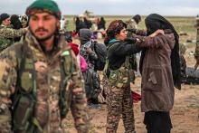 Des personnes évacuées du réduit du groupe Etat islamique à Baghouz, dans l'est de la Syrie, sont fouillées par les combattants des Forces démocratiques syriennes, le 27 février 2019