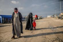 Photo prise le 17 février 2019 montrant une femme avec son petit dans le camp de déplacés d'Al-Hol qui abrite notamment des familles de jihadistes du groupe Etat islamique (EI), dans la province syrie