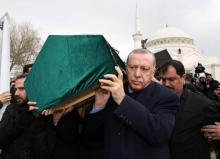 Photo diffusée par la présidence turque le 9 février 2019 montrant le président turc Recep Tayyip Erdogan portant un cercueil à l'enterrement de neuf personnes tuées dans l'effondrement d'un immeuble 