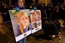 Une affiche montrant un portrait de la militante anticorruption Kateryna Gandzyuk et ses blessures après l'attaque à l'acide qui a entraîné sa mort est montrée lors d'un rassemblement en sa mémoire, à