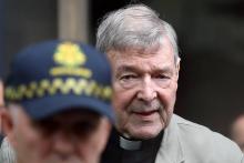 Le cardinal George Pell derrière un policier à sa sortie du tribunal de Melbourne, le 26 février 2019