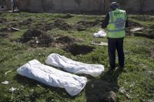 Une équipe médico-légale rassemble des cadavres après la découverte d'un charnier du groupe Etat islamique (EI) près de la ville syrienne de Raqa, le 19 février 2019