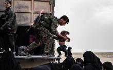 Un combattant des Forces démocratiques syriennes (FDS) durant l'évacuation de femmes et enfants du dernier réduit du groupe Etat islamique (EI), le 26 février 2019 dans la province de Deir Ezzor