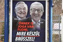 Des photos du président de la Commission européenne Jean-Claude Juncker (d) et du milliardaire et philanthrope Georges Soros au-dessus du slogan "Vous avez aussi le droit de savoir ce que Bruxelles pr