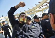 Un policier algérien saisit un manifestation lors d'un rassemblement de journalistes contre la "censure", le 28 février 2019 à Alger