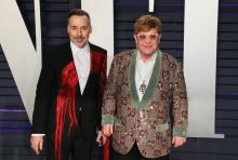 Le chanteur Elton John (D), ici avec son mari le cinéaste David Furnish après la cérémonie des Oscars le 24 février 2019, a à son tour dimanche appelé au boycott des hôtels détenus par le Sultanat de 