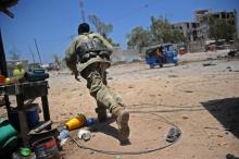 Un soldat somalien se met à l'abri pendant l'attaque de ministères par les islamistes shebab, le 23 mars 2019 à Mogadiscio.