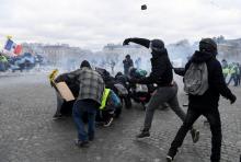 Des manifestants jettent des pavés sur les forces de l'ordre Place de l'Etoile à Paris, le 16 mars 2019