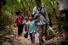 Une femme et des enfants franchissent la frontière pour se rendre du Venezuela en Colombie par des sentiers illégaux, le 4 mars 2019