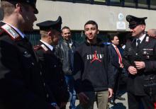 Des policiers et des pompiers près de la carcasse de l'autobus transportant une cinquantaine de collégiens pris en otages, le 20 mars 2019 près de Milan