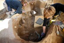 Des archéologues nettoient une tombe étrusque découverte sur le site d'Aléria, le 27 mars 2019 en Corse