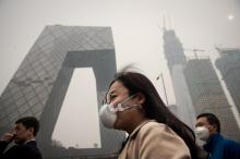 Des Chinois portent des masques de protection un jour de forte pollution à Pékin, le 20 mars 2017 en Chine