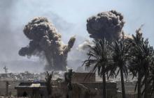 Panache de fumée après un bombardement sur le dernier réduit du groupe Etat islamique (EI) en Syrie le 18 mars 2019, un campement informel au bord du fleuve Euphrate