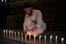 Un homme allume des bougies pour rendre hommage aux 49 victimes de l'attaque de deux mosquées à Christchurch, le 16 mars 2019