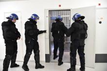 Des gardiens de prison portant des uniformes de policiers entrent dans une cellule de la prison ultrasécurisée de Condé-sur-Sarthe, près d'Alençon le 12 mars 2018